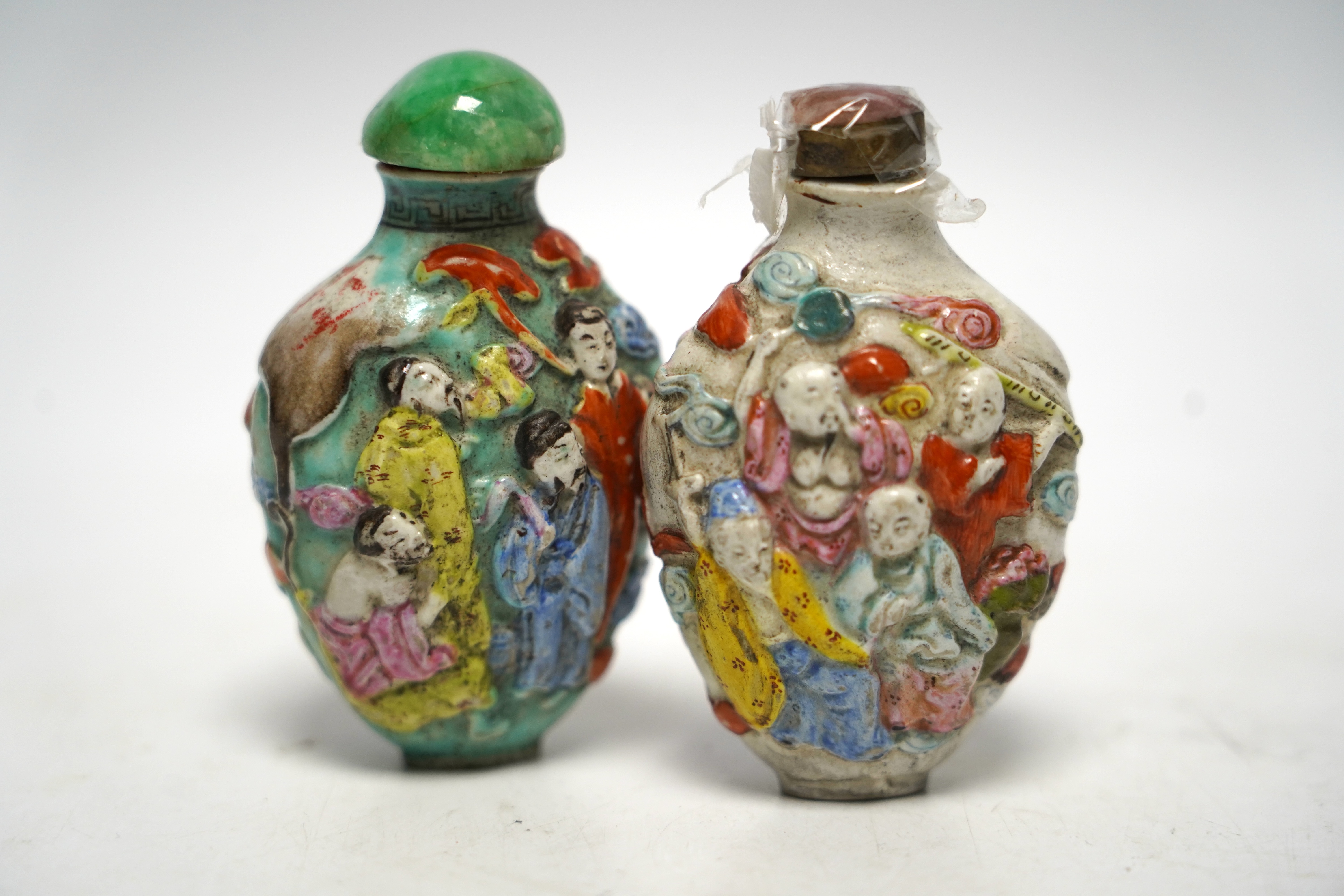 Two 19th century Chinese moulded and enamelled porcelain ’eight immortals’ snuff bottles, largest 8cm high